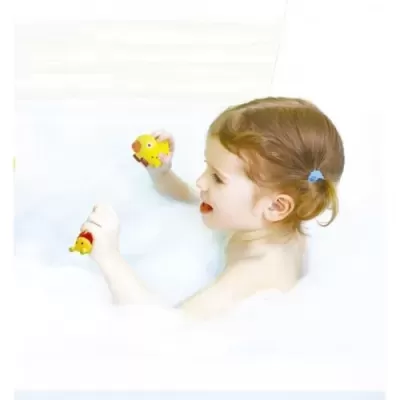 Criança na banheira a brincar com brinquedos de pato amarelos na espuma