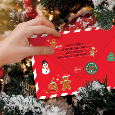 Envelope vermelho de Natal com endereço e decoração festiva em árvore de Natal