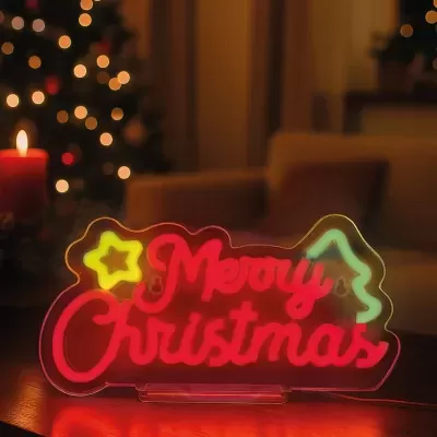Letreiro luminoso LED 'Merry Christmas' com formas natalícias em interior acolhedor