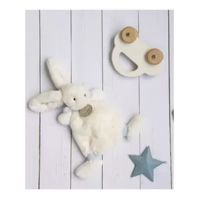 Urso de peluche branco com bonecos de madeira e estrela azul sobre prancha branca