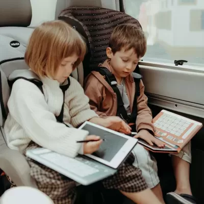 Crianças em cadeiras de carro com tablets