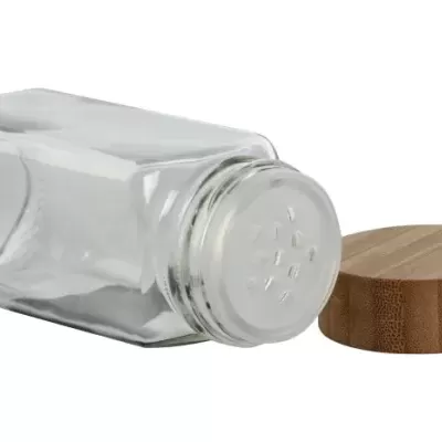 Frasco de vidro transparente com tampa metálica e tampa de madeira ao lado