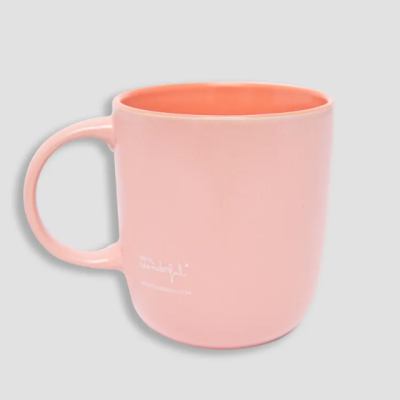 Caneca de cerâmica cor-de-rosa com interior laranja e texto branco