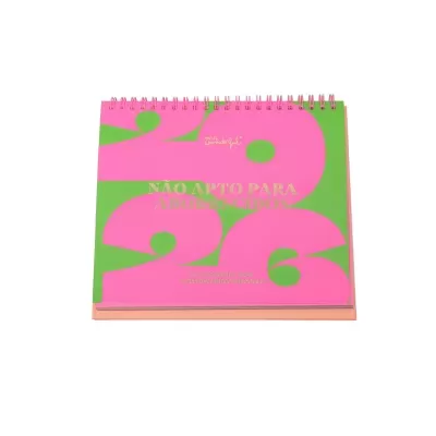 Calendário de mesa 2026 rosa e verde com texto dourado e encadernação espiral