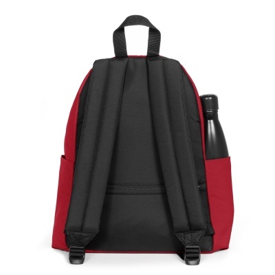 Mochila vermelha e preta vista de costas com garrafa preta no bolso lateral.