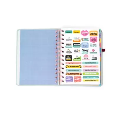 Agenda aberta com autocolantes coloridos organizados numa página ao lado de uma página azul quadriculada.
