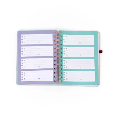 Agenda aberta com folhas interiores azuis e lilás, anéis metálicos cor-de-rosa e espaços para anotações com ícones.