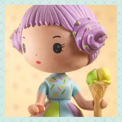 Boneca de figura de ação com cabelo roxo e vestido colorido segurando cone de gelado.