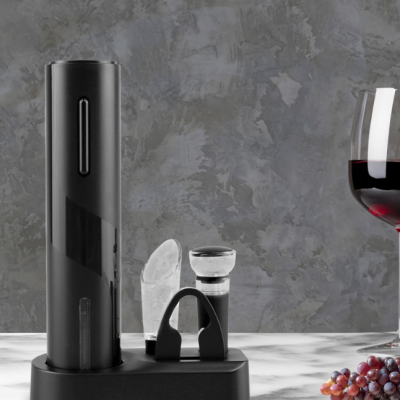 Conjunto de acessórios para vinho preto com suporte, copo de vinho tinto e uvas sobre mesa de mármore.