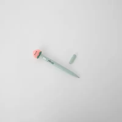 Caneta verde clara com ponta decorativa cor-de-rosa com olhos desenhados