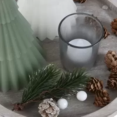 Tabuleiro com vela, castiçais em forma de árvore, pinheiro e pinhas.