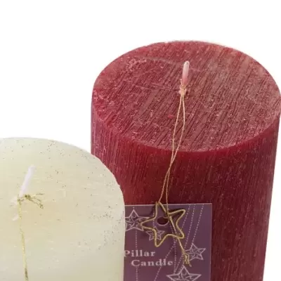 Duas velas de pilar, uma branca e uma vermelha, em fundo branco