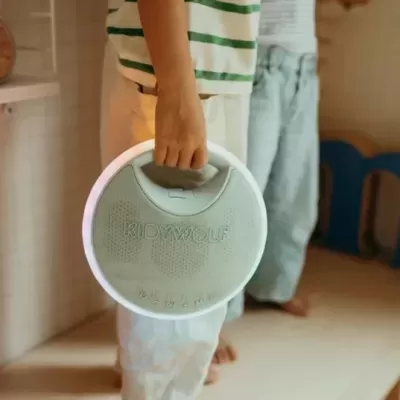 colaborador segura coluna de som redonda cinza claro com luz LED circular