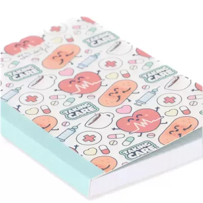 Caderno com capa branca decorada com desenhos de corações, comprimidos, seringas e frases TAKING CARE.