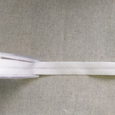 Fita de tecido branca sobre tecido cinza claro com texto Cor 1