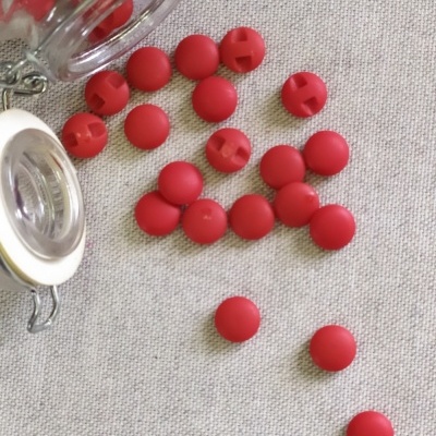 Bolas vermelhas de plástico espalhadas junto a frascos de vidro com tampa de metal