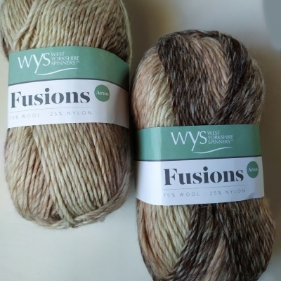 Dois novelos de lã Fusions Aran da WYS com etiqueta verde e branca, cor 880, em tons mesclados de bege e castanho