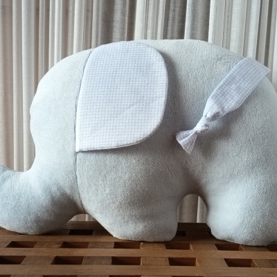 Pelúcia de elefante cinzento claro com orelhas e cauda padrão pied de poule em fundo neutro