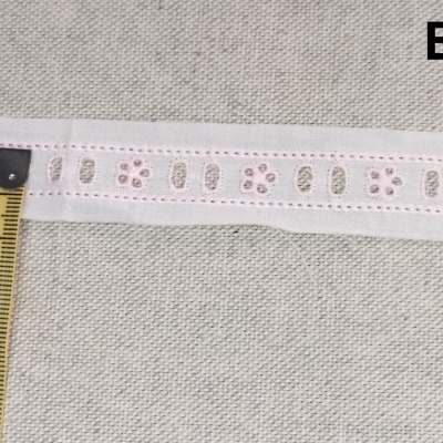 Faixa branca com padrões recortados e fita métrica amarela