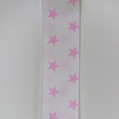 Tira branca com estrelas cor-de-rosa e clipe branco em fundo cinzento