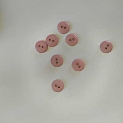 Botões redondos rosa com dois furos sobre fundo branco