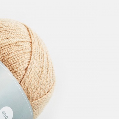 Novelo de lã bege com etiqueta cinzenta