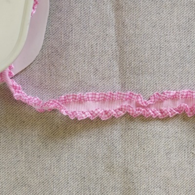 Fita elástica rosa ondulada com padrão xadrez.