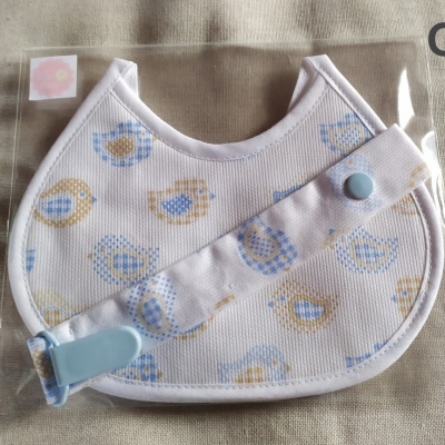 Babete e fita para chupeta com padrão de pássaros em tecido branco