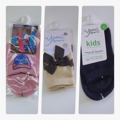 Três pares de meias infantis em rosa, bege e azul-escuro com etiquetas da marca Ysabel Mora