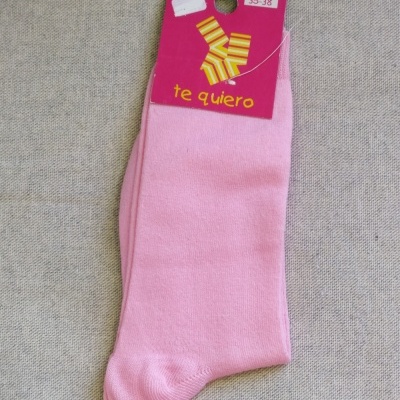 Meias cor-de-rosa com etiqueta rosa e letras amarelas no fundo cinza