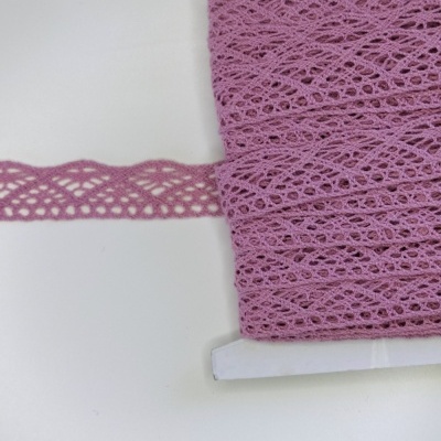 Rolo de renda cor-de-rosa com padrão de malha entrelaçada sobre fundo branco