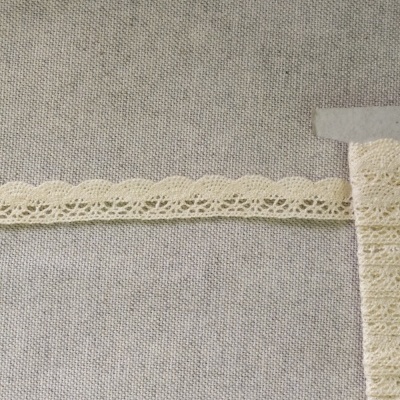 Renda fina bege clara em tecido cinzento com texto Renda 23
