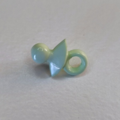 Chupeta verde claro de plástico sobre superfície branca