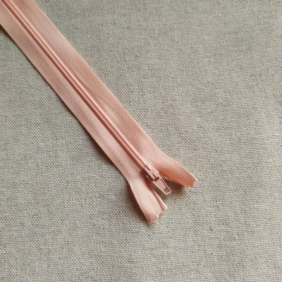 Fecho éclair rosa claro sobre tecido cinza com texto Cor 536