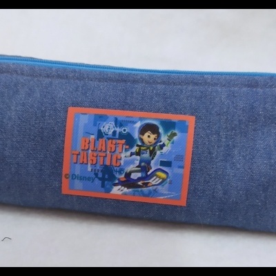 Estojo azul com etiqueta colorida e fecho de correr azul