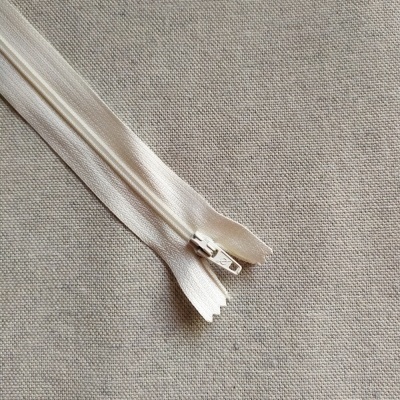 Fecho éclair branco com cursor metálico sobre tecido cinza, texto 'Cor 503'