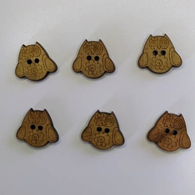 Seis botões de madeira em forma de cão com padrões florais e olhos pretos, sobre fundo branco e texto Mocho