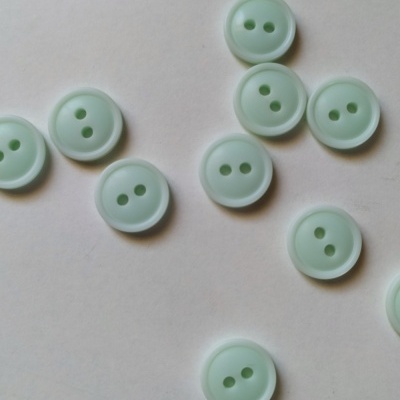 Botões verdes claros redondos em superfície branca