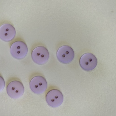 Botões lilás de plástico com dois furos sobre superfície branca
