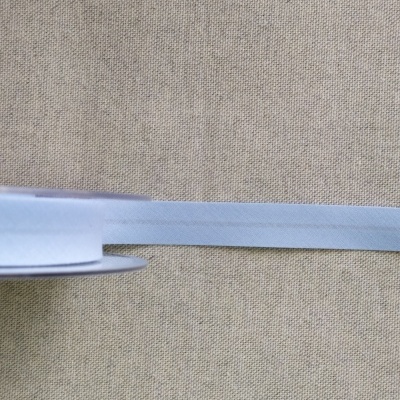 Rolo de fita branca estreita sobre tecido bege com 'Cor 11'