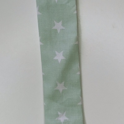 Prendedor de chucha verde claro com estrelas brancas e presilha branca