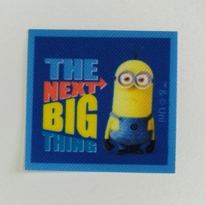 Etiqueta azul com Minion amarelo e texto THE NEXT BIG THING