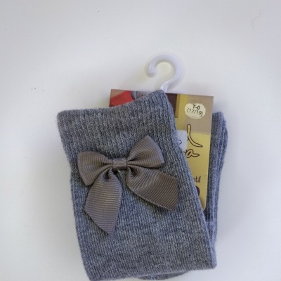 Meias cinzentas com laço castanho claro e etiqueta de tamanho numa superfície branca.