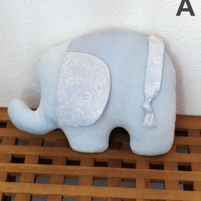 Almofada azul claro em forma de elefante com orelha estampada e laço