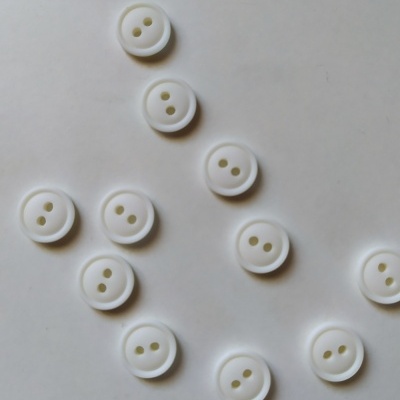 Doze botões brancos redondos com dois orifícios