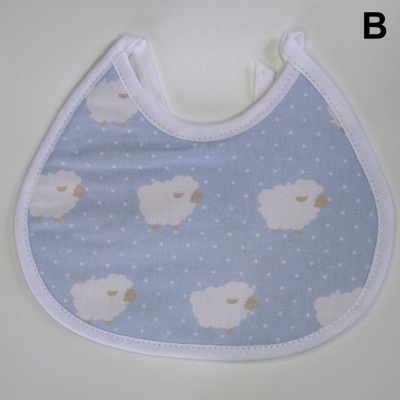 Babete azul claro com ovelhas brancas e bordas brancas