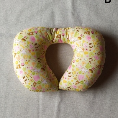 Almofada de pescoço amarela com padrão infantil e letra D no canto