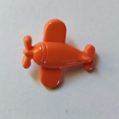 Brinquedo de avião de plástico laranja sobre fundo branco