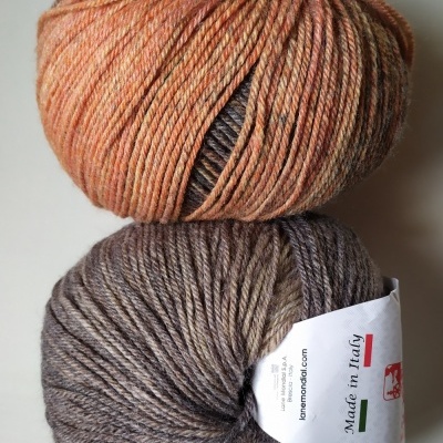 Dois novelos de lã em tons de laranja e castanho e castanho e cinzento com etiqueta 'Made in Italy'