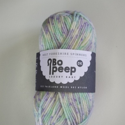 Novelo de lã em tons pastel com etiqueta preta e texto Cor 868